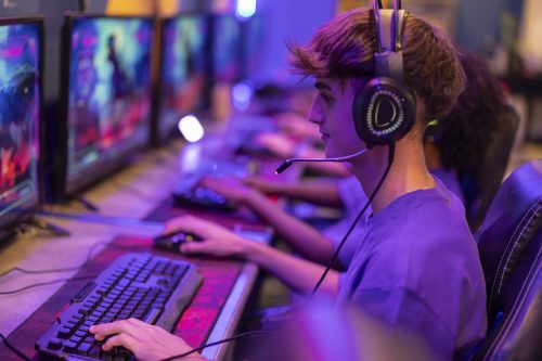 Focused online gaming player with headset interacting in a real-time gaming environment
