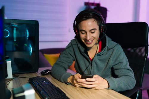 Young online gaming user in Mexico viewing SMS gaming bonus offers on a smartphone during a gaming session